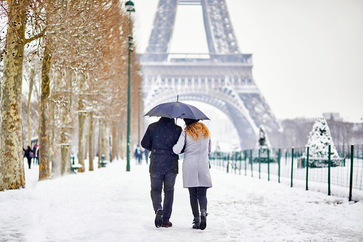 一对夫妇在巴黎冬天的雪地里散步